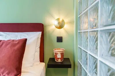 a bedroom with a bed and a vase on a table at The Mila Hotel in Brussels