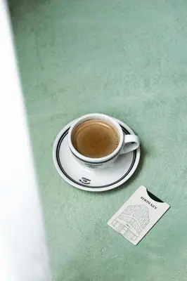 a cup of coffee on a plate on a table at The Mila Hotel in Brussels