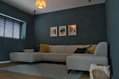 a living room with a couch and a blue wall at Vakantiewoning DRP29 in Zelem