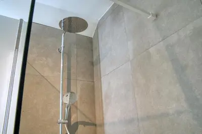 a shower with a glass door in a bathroom at Vakantiewoning DRP29 in Zelem