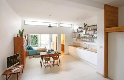 a kitchen and living room with a table and chairs at Lounge in the Intimate Urban Garden at a Retro Getaway in Ghent