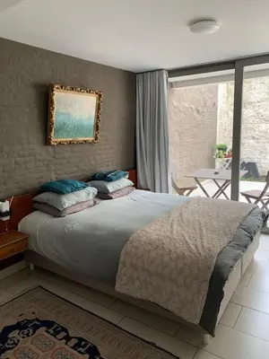 a bedroom with a large bed and a balcony at Lounge in the Intimate Urban Garden at a Retro Getaway in Ghent