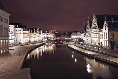 a city at night with a river and buildings at Lounge in the Intimate Urban Garden at a Retro Getaway in Ghent