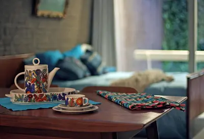 a table with cups and saucers on top of it at Lounge in the Intimate Urban Garden at a Retro Getaway in Ghent