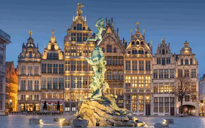 a statue in front of a large building at KYOTO SUITES - Antwerp in Antwerp