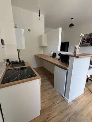 a kitchen with white cabinets and a counter top at Studio Nour in Brussels