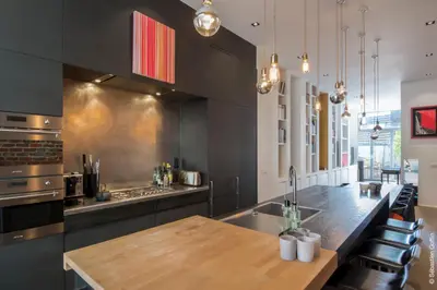a kitchen with a wooden table and a counter top at Flagey Terrace Design residence in Brussels