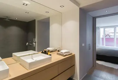 a bathroom with two sinks and a large mirror at Flagey Terrace Design residence in Brussels