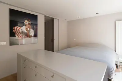 a bedroom with a bed and a painting on the wall at Flagey Terrace Design residence in Brussels