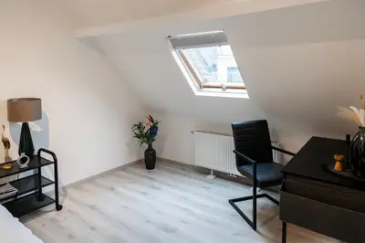 a room with a chair and a desk and a window at Unique Parking access, XL home w Parking option in Antwerp