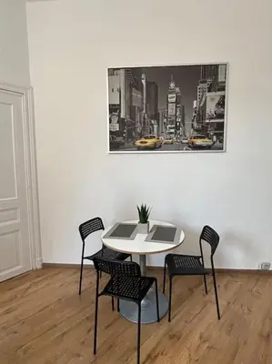 a table and chairs in a room with a picture on the wall at Studio Issa in Brussels