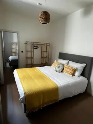 a bedroom with a large bed with a yellow blanket at Beautiful apartment Antwerp in Antwerp