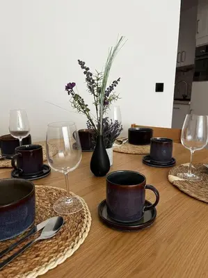 a wooden table with wine glasses and plates on it at Beautiful apartment Antwerp in Antwerp