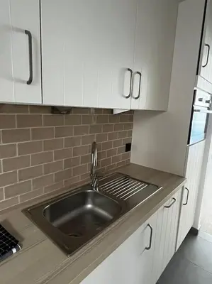 a kitchen with a sink and white cabinets at Beautiful apartment Antwerp in Antwerp