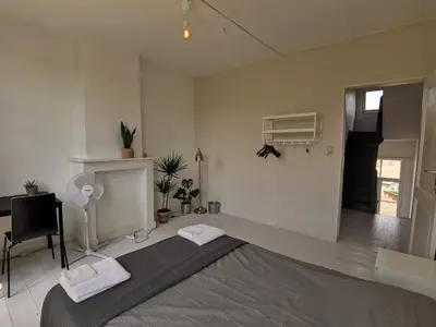 a bedroom with a bed and a desk and a fan at Private room near Gravensteen in Ghent