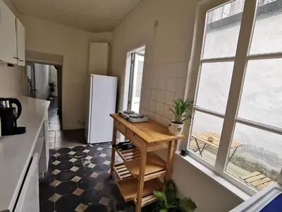 a kitchen with a table and a refrigerator in a room at Private room near Gravensteen in Ghent