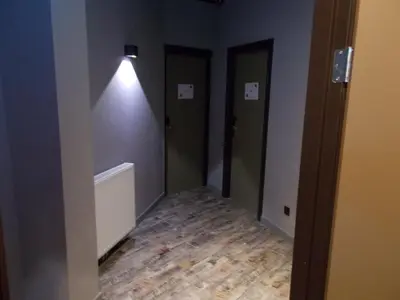 a hallway with three doors and a light on the wall at Urban City Centre Hostel in Brussels