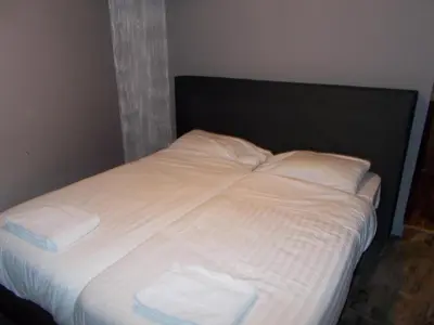 a bed with white sheets and two towels on it at Urban City Centre Hostel in Brussels