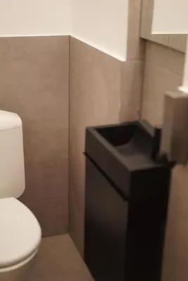 a bathroom with a toilet and a black counter at Skyway airport apartments in Zaventem