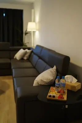 a black couch with a tray of water bottles on it at Skyway airport apartments in Zaventem