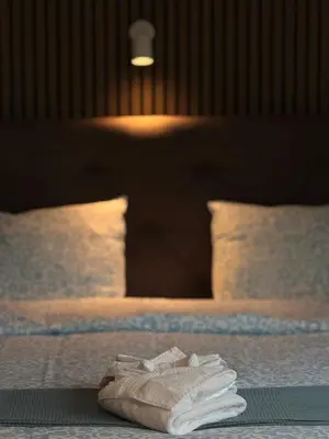 a pile of towels sitting on top of two beds at Skyway airport apartments in Zaventem