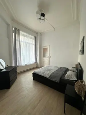 a bedroom with a bed and a ceiling fan at Authentique appartement in Brussels