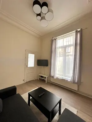 a living room with a couch and a table at Authentique appartement in Brussels