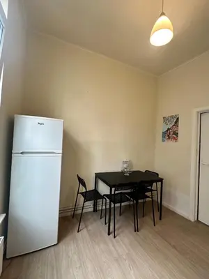 a kitchen with a black table and a white refrigerator at Authentique appartement in Brussels