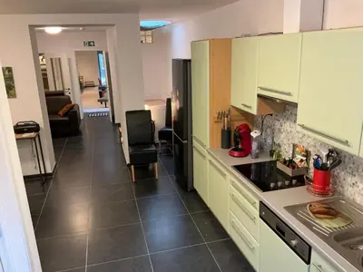 a kitchen with green cabinets and a black refrigerator at Aura Diest in Diest
