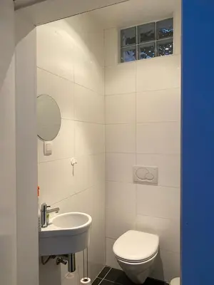 a white bathroom with a toilet and a sink at Aura Diest in Diest