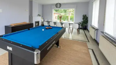 a living room with a pool table and chairs at Nethehuis in Kasterlee