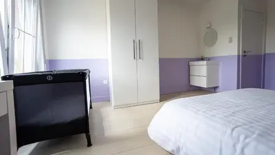 a bedroom with purple and white walls and a bed at Nethehuis in Kasterlee