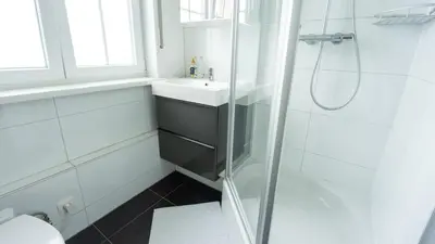 a white bathroom with a sink and a shower at Nethehuis in Kasterlee