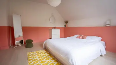 a bedroom with a white bed and a red wall at Nethehuis in Kasterlee