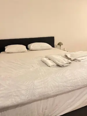 a white bed with white sheets and pillows on it at visit Brussels city in Brussels