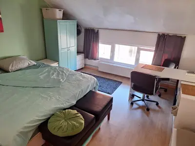 a bedroom with a bed and a desk and a computer at Cozy house in Ghent