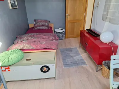 a small bedroom with a bed and a dresser at Cozy house in Ghent