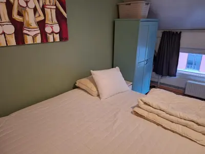 a small bedroom with a bed and a blue cabinet at Cozy house in Ghent