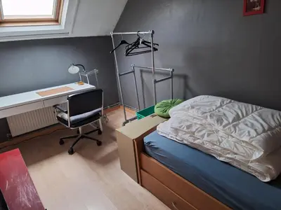 a bedroom with a bed and a desk and a deskablish at Cozy house in Ghent