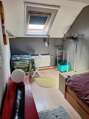 a attic bedroom with a bed and a window at Cozy house in Ghent
