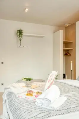 a white bed with towels on top of it at Garden View Apt in Ghent in Ghent