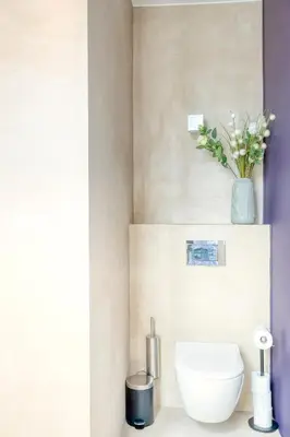 a bathroom with a toilet and a vase with flowers at Garden View Apt in Ghent in Ghent