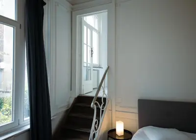 a bedroom with a staircase and a bed and a window at Prestige Stay - Uptown in Brussels