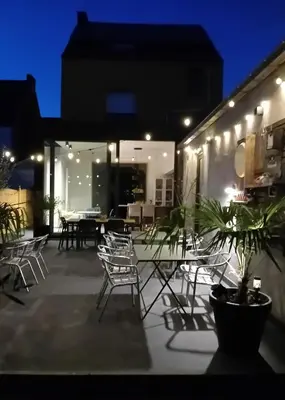 a group of chairs and tables on a patio at night at ' t Geel Huizeken - B&B - koffiehuis in Denderleeuw