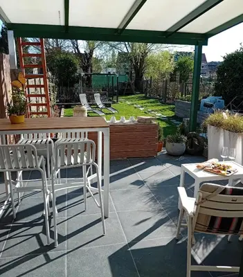 a patio with chairs and a table and a pergola at ' t Geel Huizeken - B&B - koffiehuis in Denderleeuw