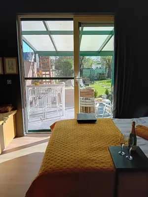 a bedroom with a bed and a view of a patio at ' t Geel Huizeken - B&B - koffiehuis in Denderleeuw