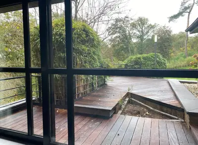 a view of a wooden deck from a window at Villa des Templiers - 20 min Brussels Airport in Wavre
