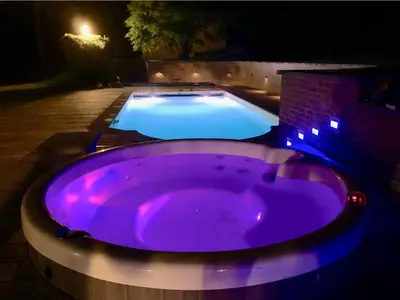 a purple hot tub in a backyard at night at Villa des Templiers - 20 min Brussels Airport in Wavre