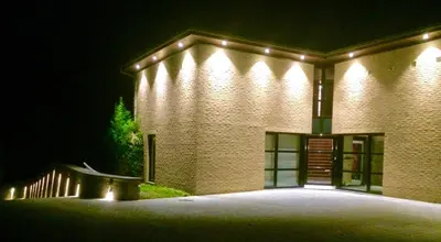 a brick building with lights on it at night at Villa des Templiers - 20 min Brussels Airport in Wavre