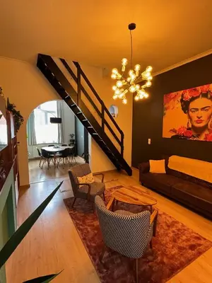 a living room with a staircase and a couch at Vakantiewoning Huis 14 in Mechelen